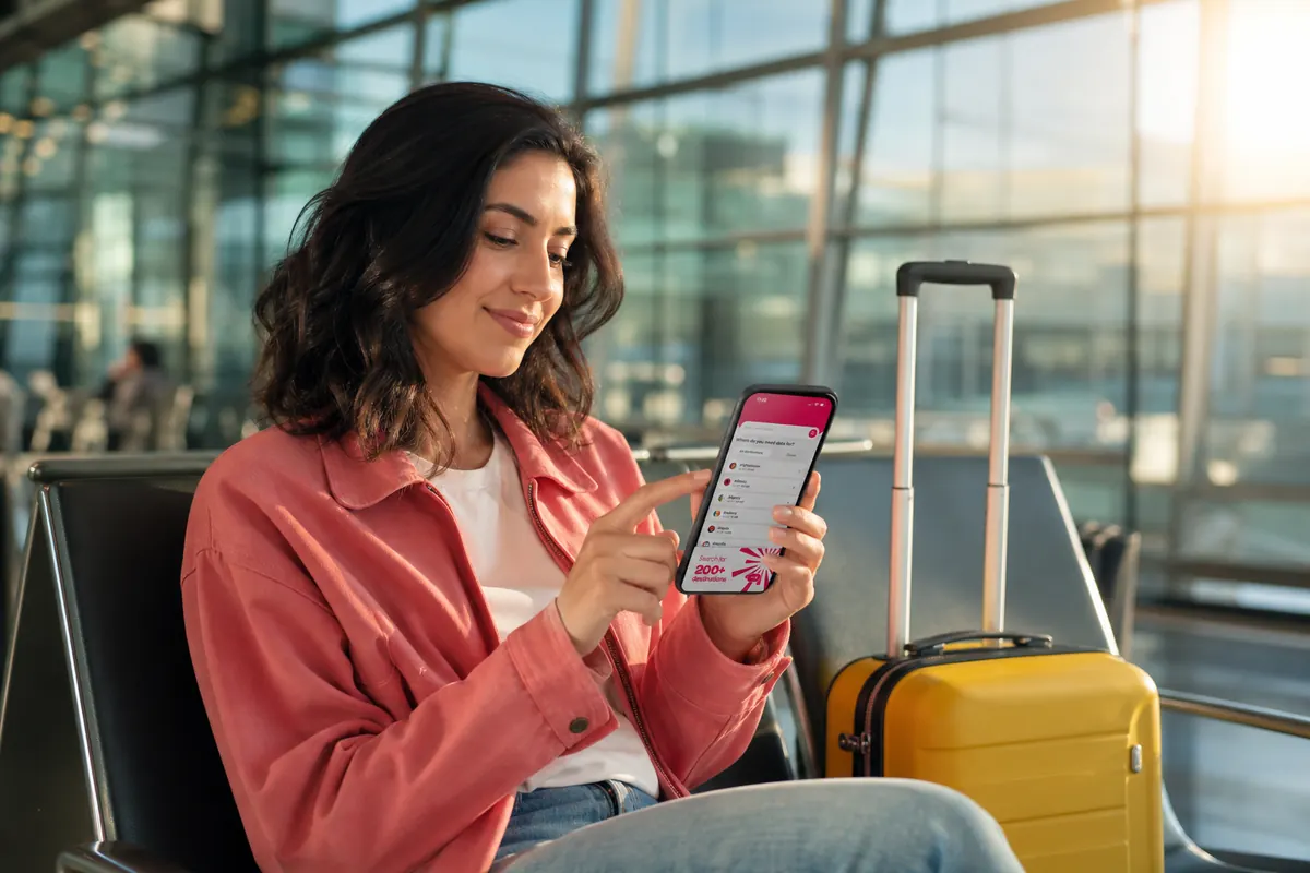 Traveler at the airport disabling data roaming on their smartphone settings.