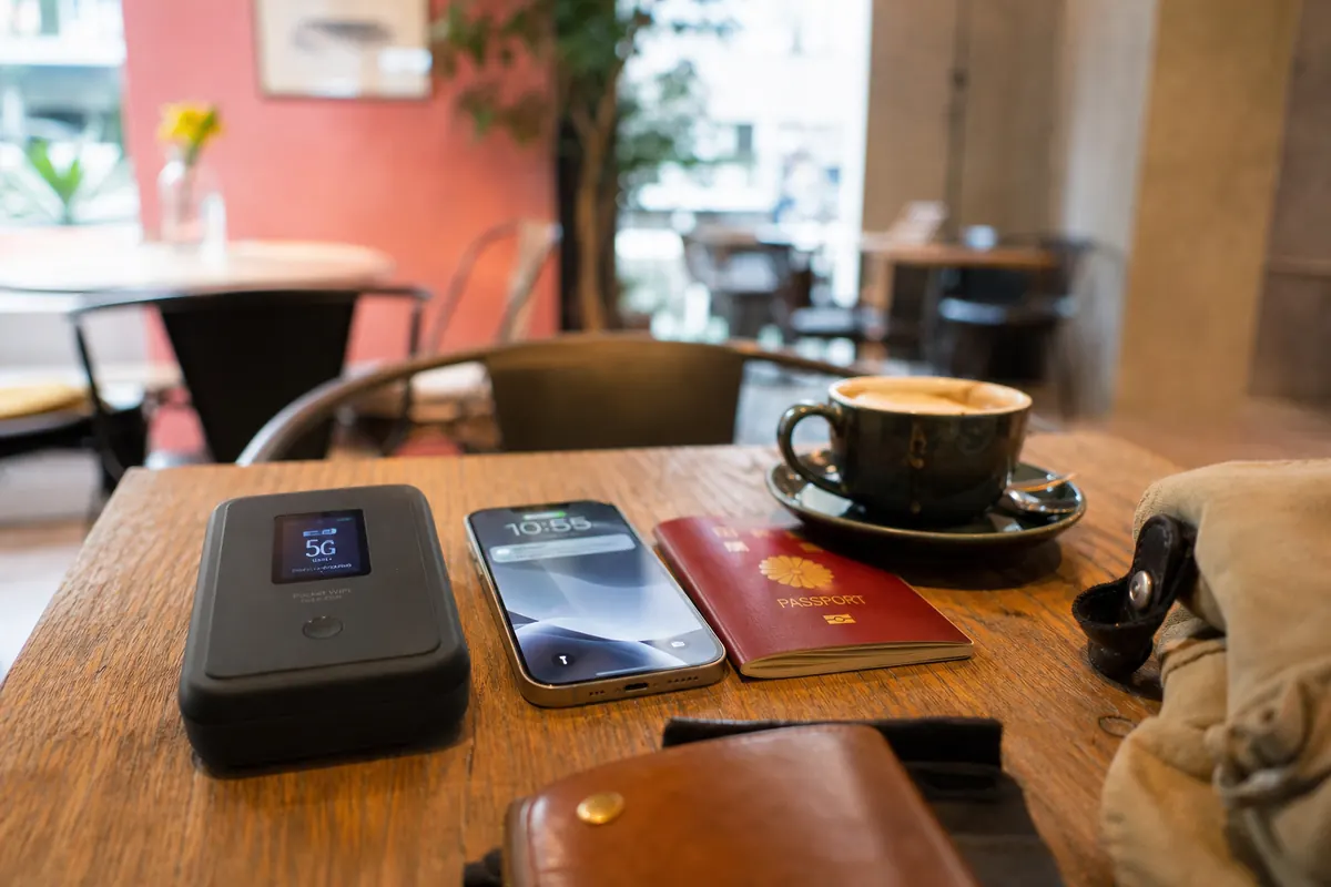 Bulky pocket WiFi, smartphone and passport on a cafe table.
