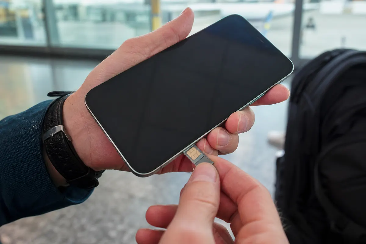 Traveler checking the network connection of their iPhone 13 abroad.