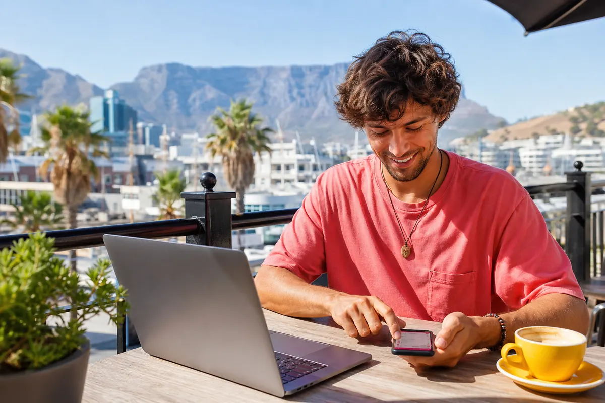 Traveler using an eSIM on their smartphone at Cape Town airport.