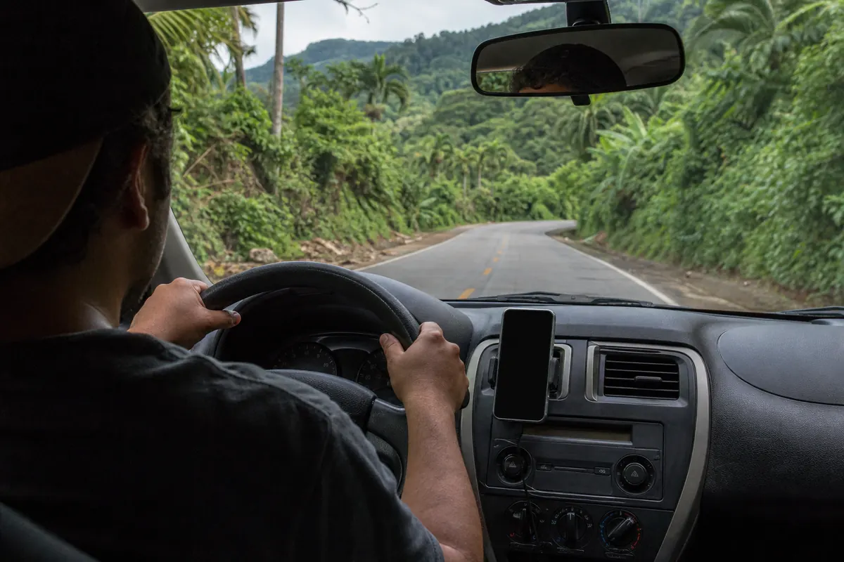 Père de famille conduisant au Mexique, utilisant son téléphone comme GPS.